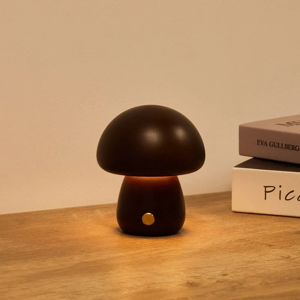 Wooden mushroom cordless table lamp, lit on a wooden table