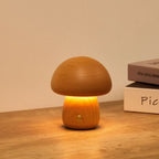 Wooden mushroom cordless table lamp, lit on a wooden table
