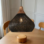 Woven rattan teardrop pendant light, in black above a table